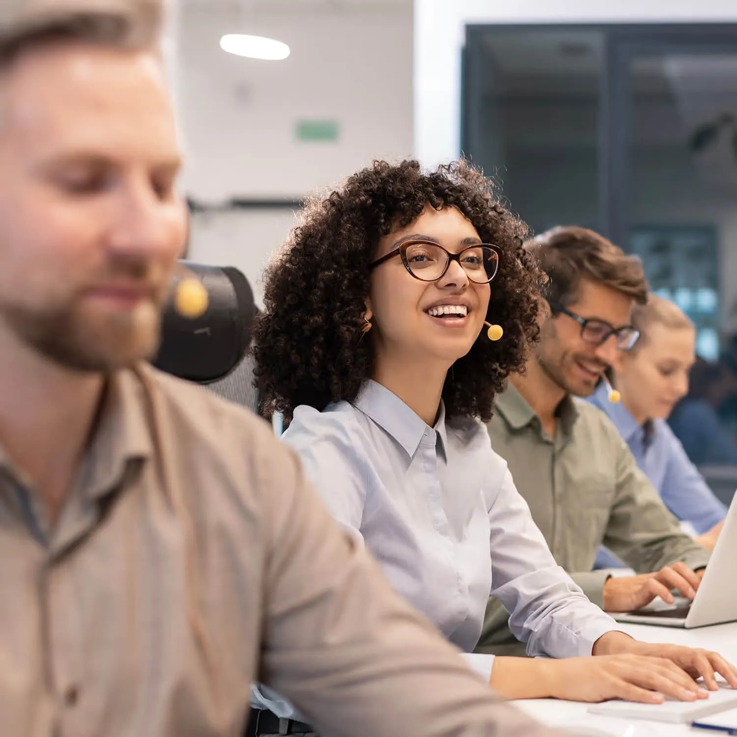 Successful call center operators working together in a modern office environment