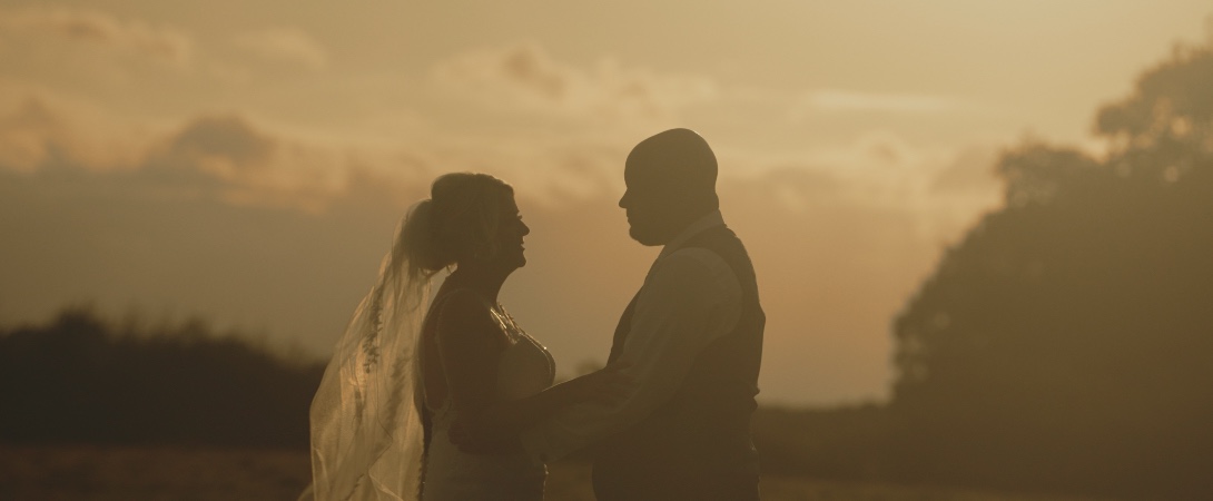 mark and suzy golden hour portrait underneath tree at sandhole oak barn