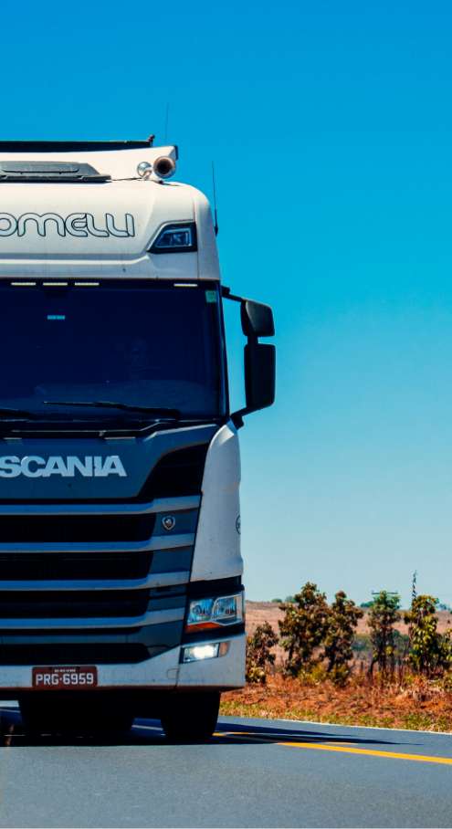 Un semi-remorque blanc avec le mot Scania inscrit à l'avant.