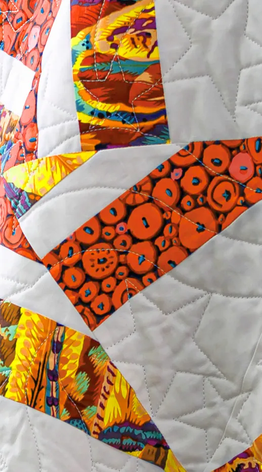 a close up of an orange and white quilt