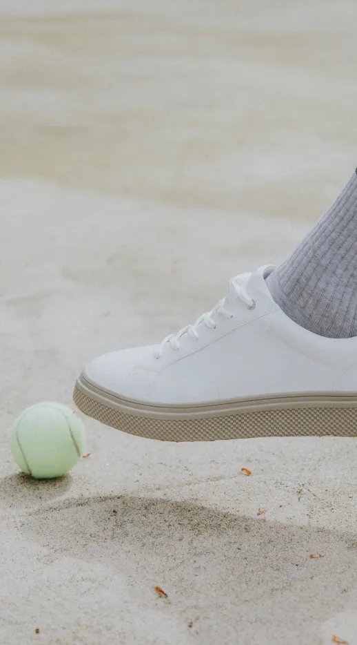 a person standing next to a tennis ball