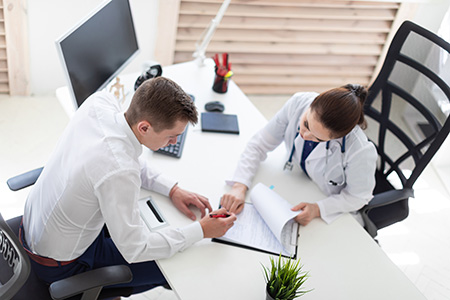 a female doctor getting a signature on a chart