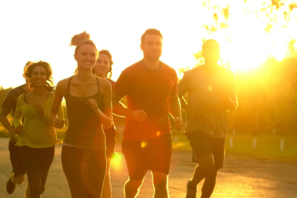 Group of runners on road at sunset