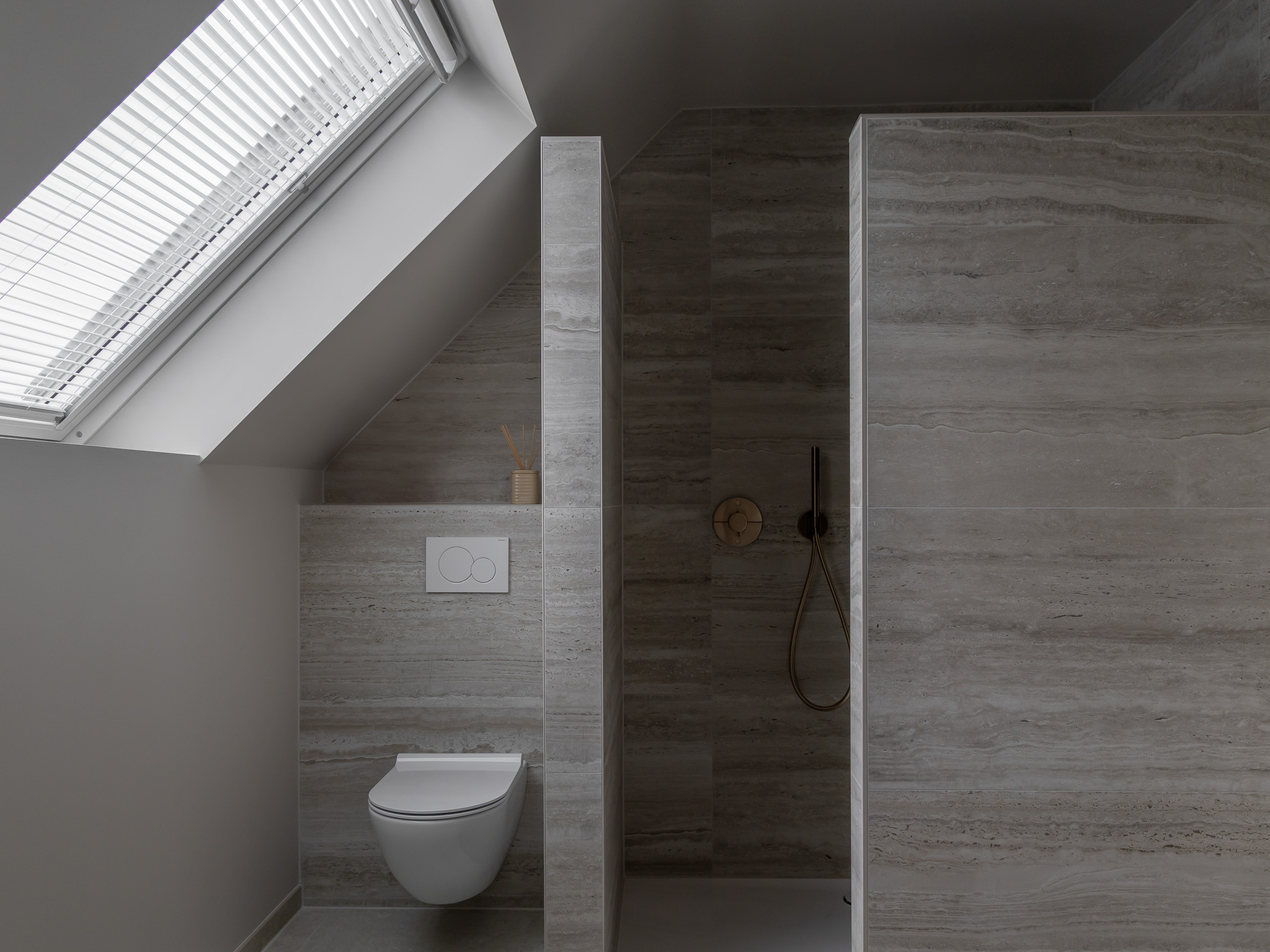 Foto van een gerenoveerde badkamer. Hier zie je de douche en het toilet.