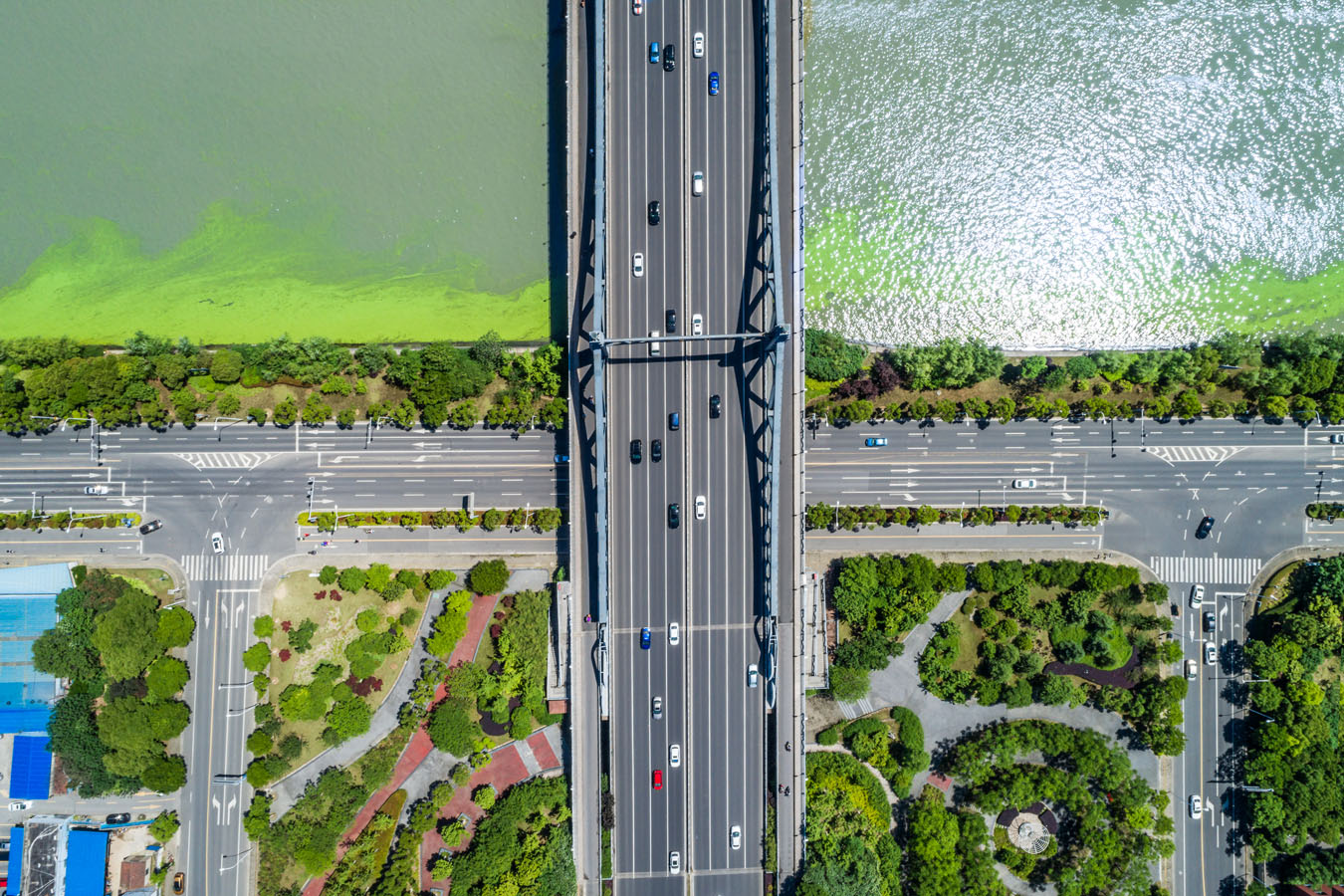 An aerial view of a street intersection with a lake in the background.