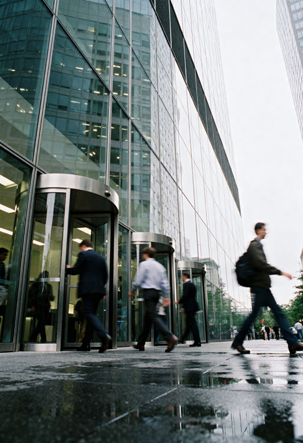 A group of people walking past a tall building.