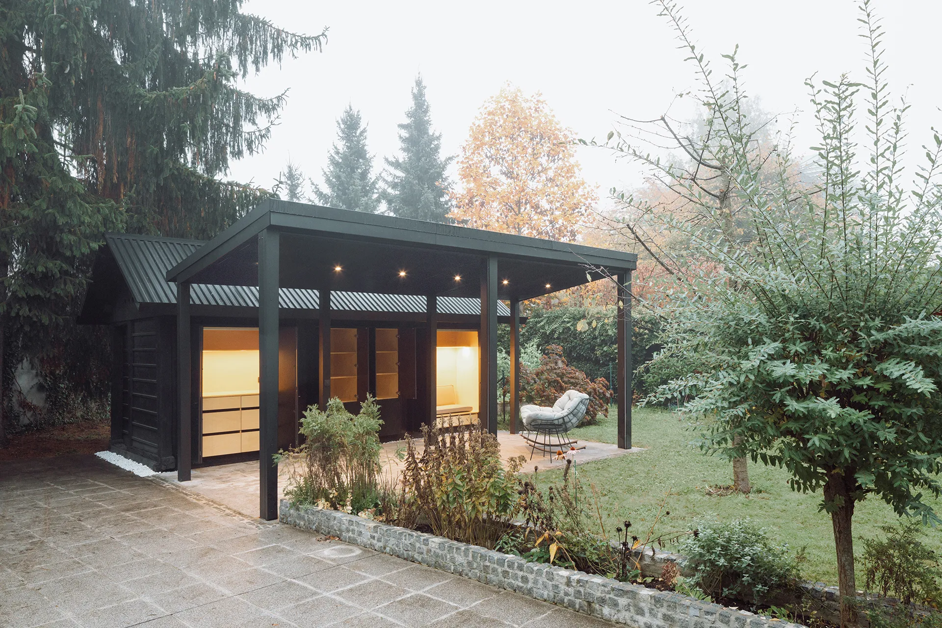 čebelnjak v jesenskem, meglenem jutru, v polsvetlobi, s prižganimi zunanjimi svetili