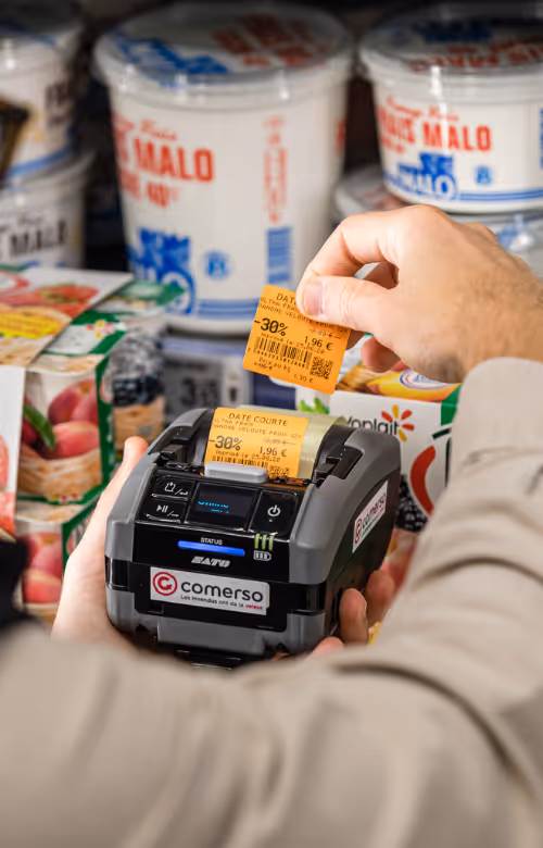 Un employé de supermarché imprime une étiquette de promotion destinée à un yaourt date courte