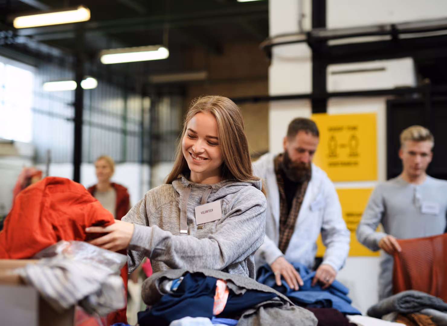 Une bénévole trie les vêtements reçus par son association pour les redistribuer