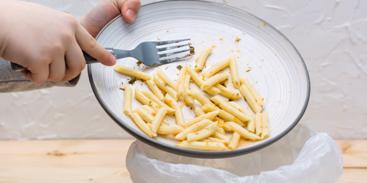Personne jette des pâtes à la poubelle