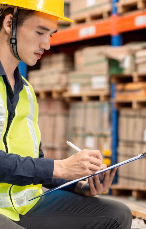Un employé dans un entrepôt coche la marchandise déstinée au don
