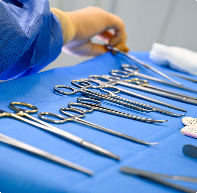 Instruments chirurgicaux disposés sur un champ stérile bleu avant une opération
