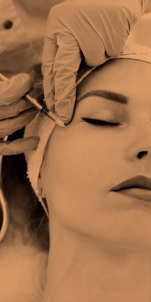 A person receiving an injection near the eye by a gloved professional.