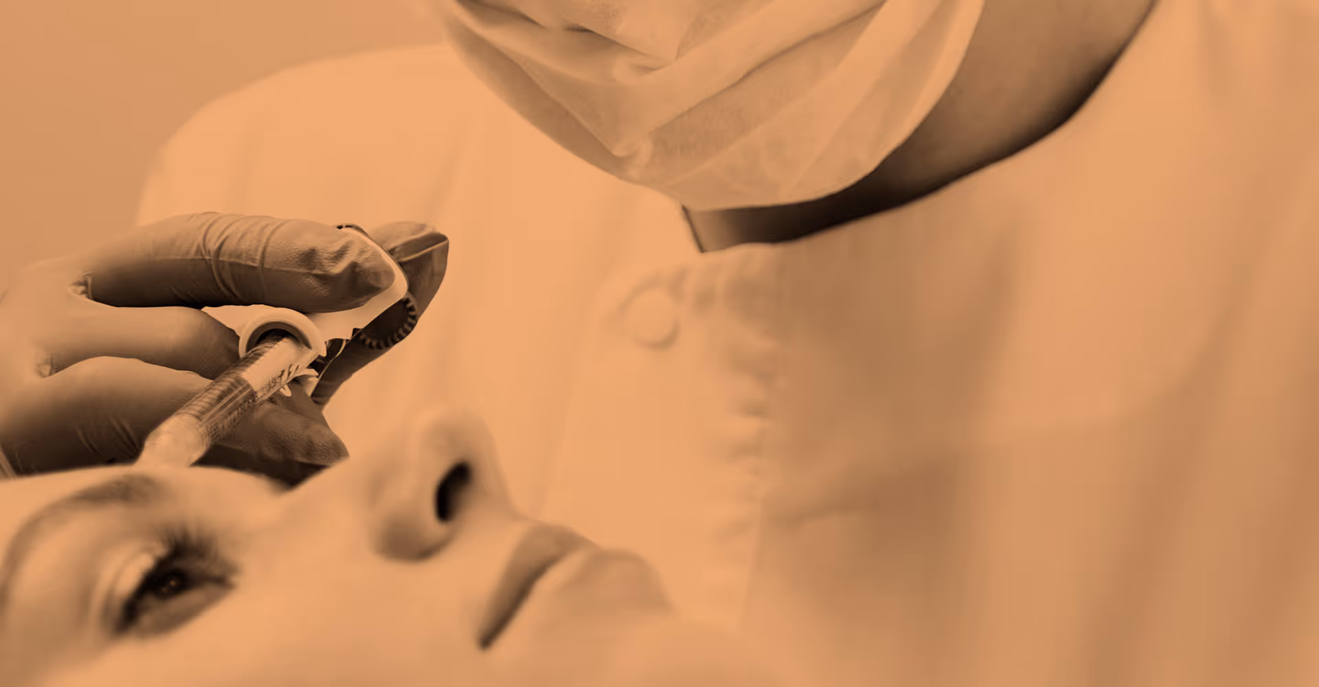 Person in medical gloves injecting a substance into another person's face.