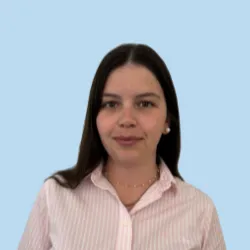 Lächelnde Frau in gestreifter Bluse vor blauem Hintergrund