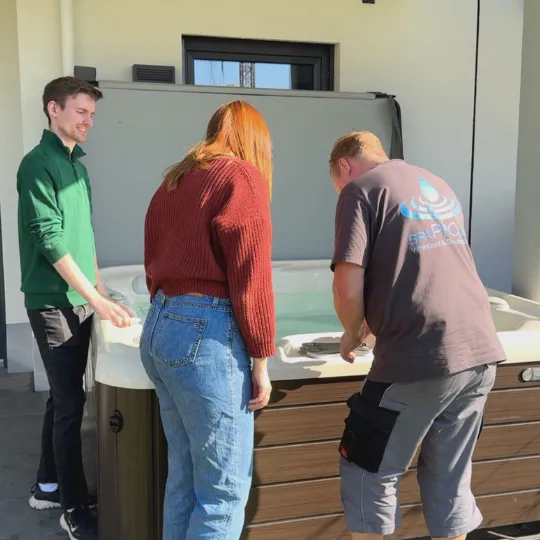 Drei Personen arbeiten zusammen an einem großen weißen Arbeitstisch