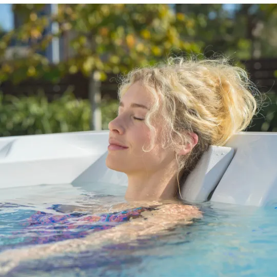 Entspannte Frau mit geschlossenen Augen im Whirlpool im Freien