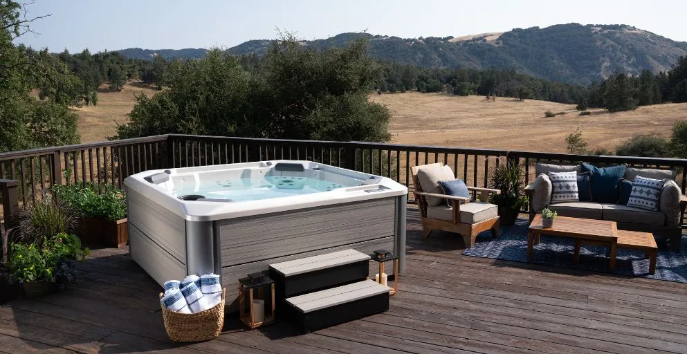 Whirlpool auf Holzterrasse mit Bergblick und gemütlichen Sitzmöbeln
