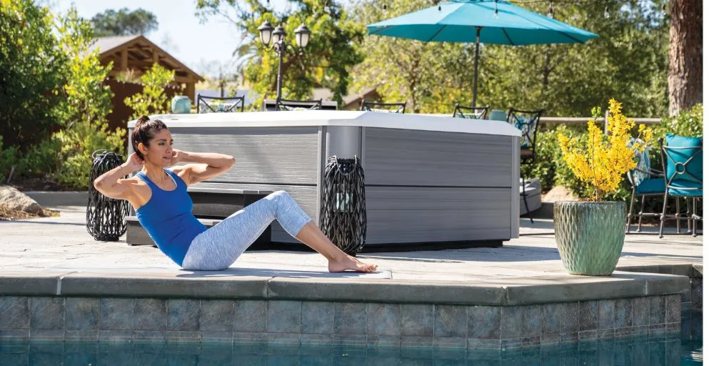 Zwei Personen entspannen in einem blau beleuchteten Whirlpool bei Nacht