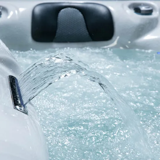 Wasserstrahl in einem Whirlpool mit schäumendem, blauem Wasser