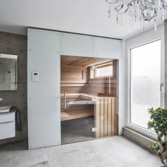 Moderner Saunaraum mit Holzinnenausstattung und Glasfront in hellem Badezimmer
