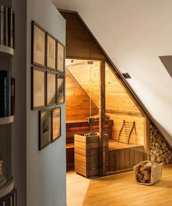 Rustikale Holz-Sauna im Dachgeschoss mit Glaswand und Bilderrahmen