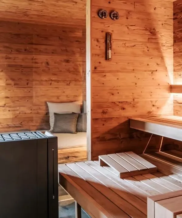 Gemütliche Holz-Sauna mit Sitzbank, Ofen und warmen Farbtönen