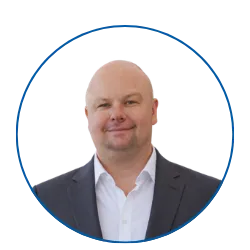 Lächelnder Mann im Anzug vor blauem Kreis