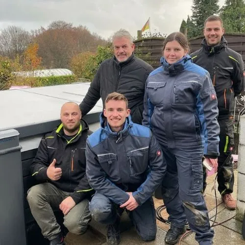 Arbeitsgruppe in warmer Winterkleidung im Freien posierend