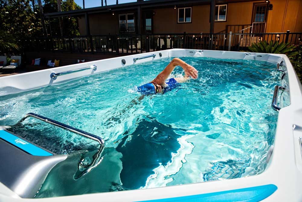 Schwimmer krault gegen den turbulenzfreien Gegenstrom in einem Endless Pools E550 SwimSpa