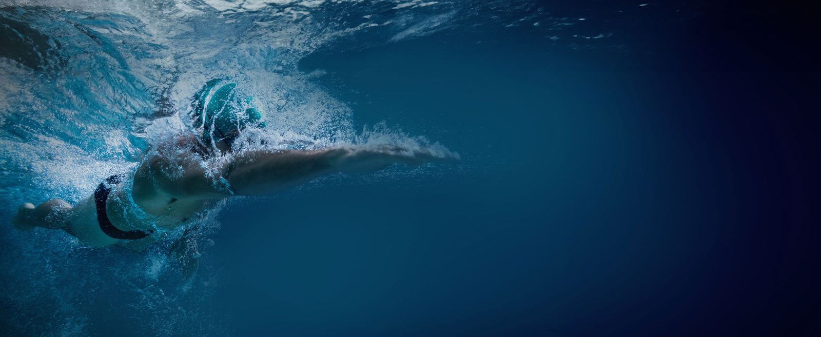 Schwimmerin trainiert in einem SwimSpa mit geöffneter Covana Legend Abdeckung
