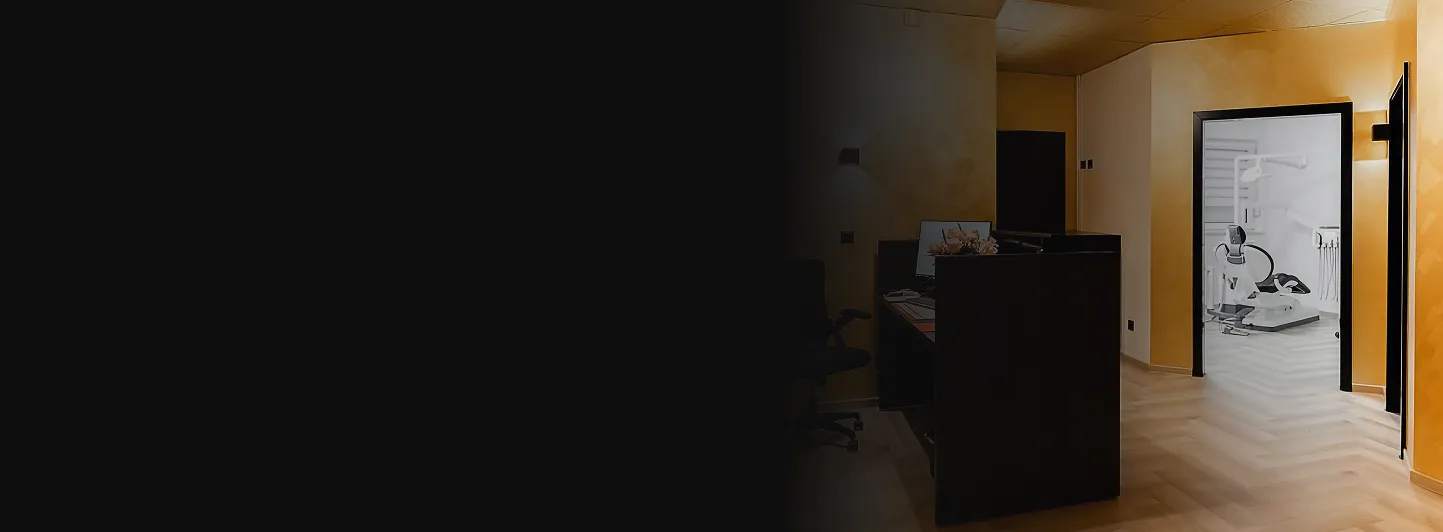 Moderner Eingangs- und Empfangsbereich einer Zahnarztpraxis mit warmen Beleuchtungstönen und Blick in ein Behandlungszimmer