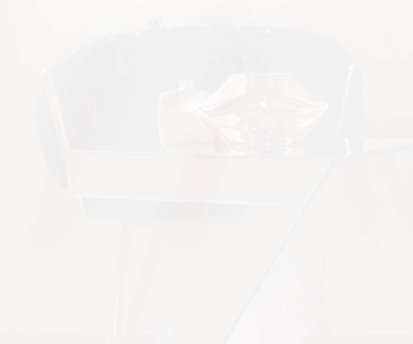 Detailaufnahme eines eleganten Wartebereichs mit dunkel gepolstertem Designstuhl und goldenem Dekoelement auf modernem Z-förmigem Tisch