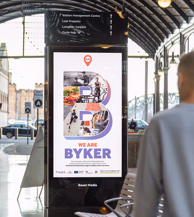 A train station advertisement screen promoting a leisure centre