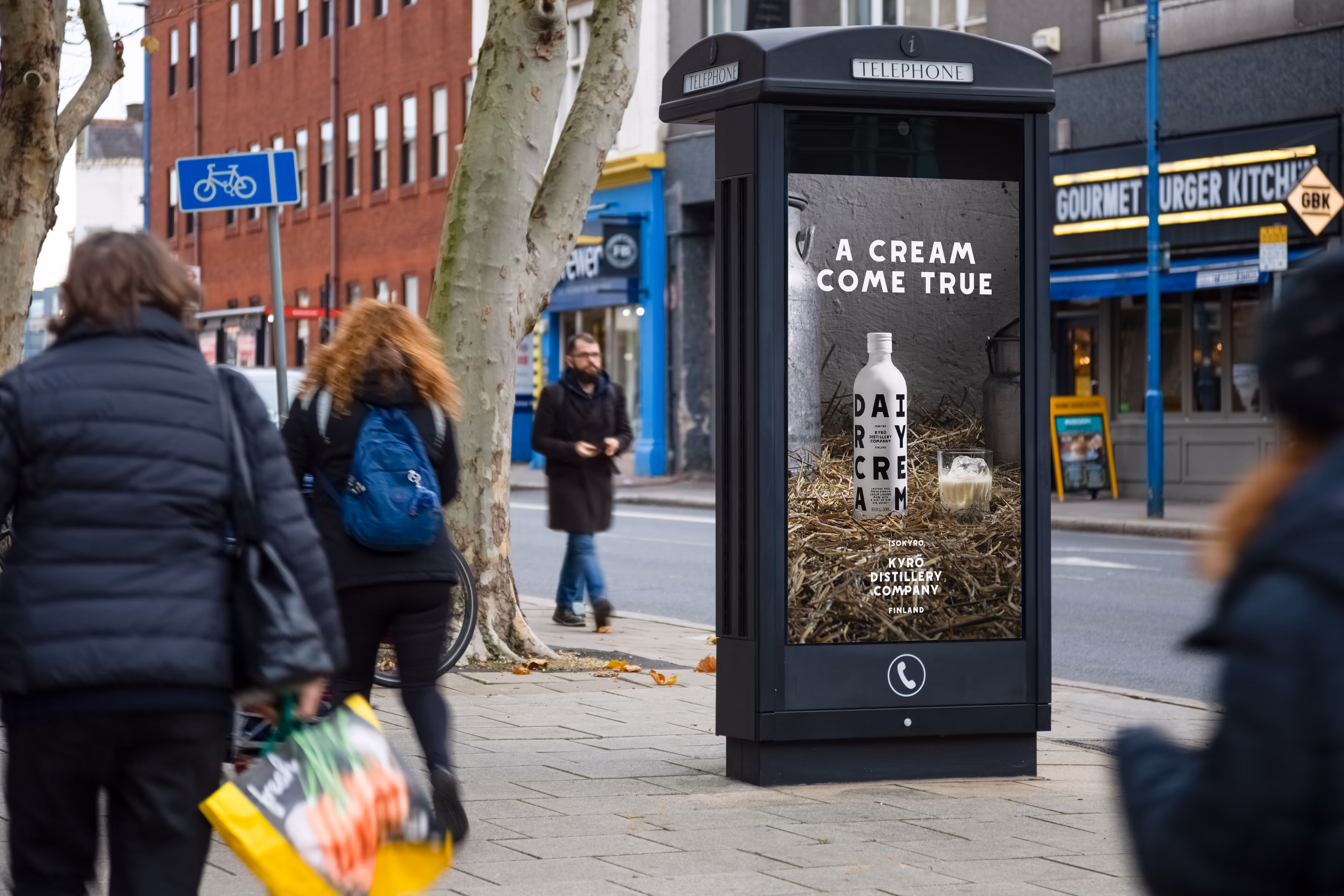 Digital phone box screen outside Gourmet Burger showing ad Kyro distillery
