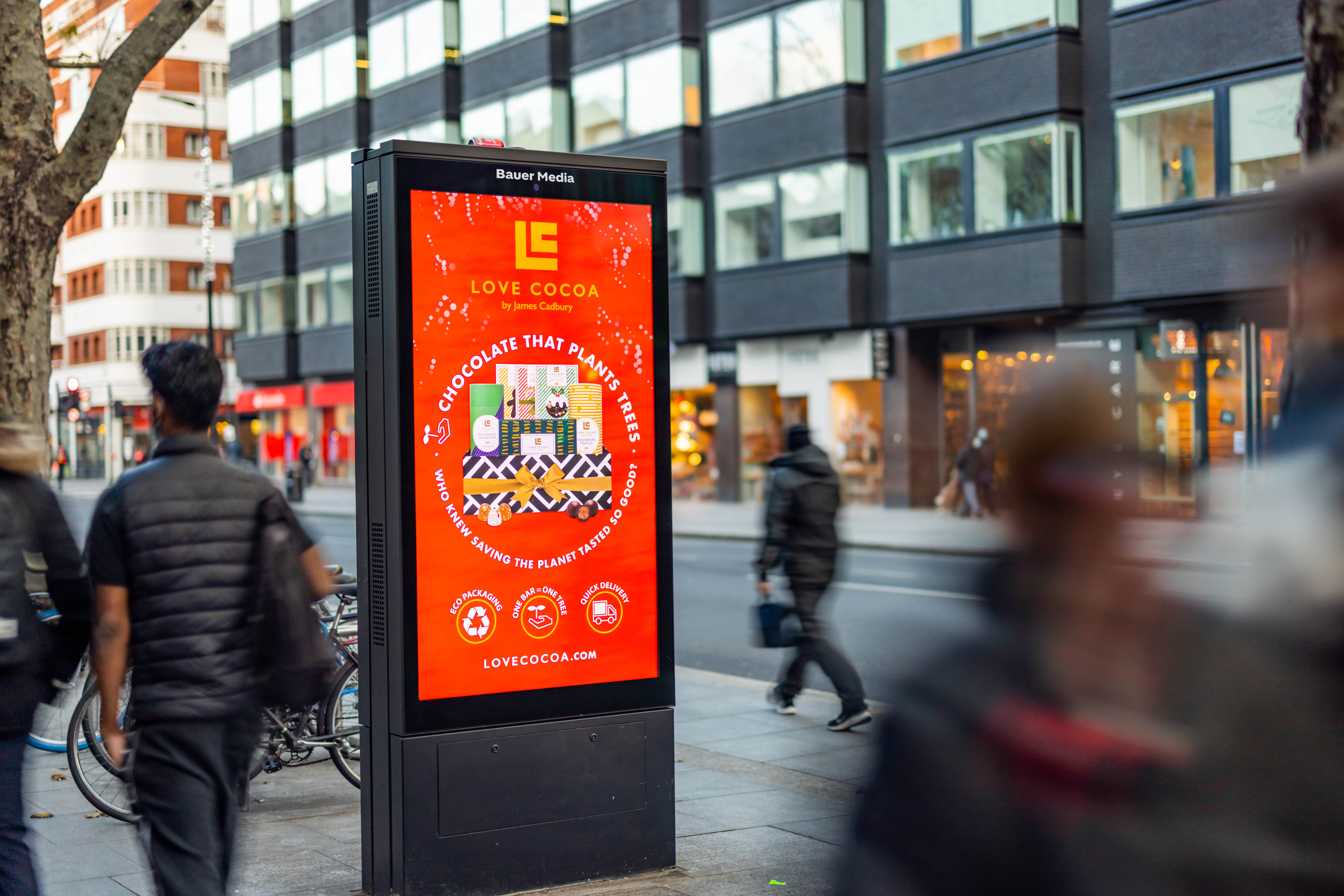 Bright red Love Cocoa ad with people walking past