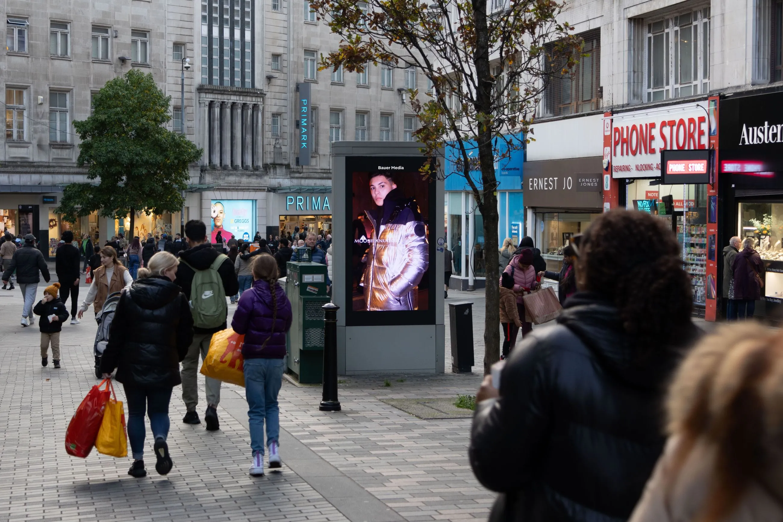 Digital advertisement in the middle of a busy high street
