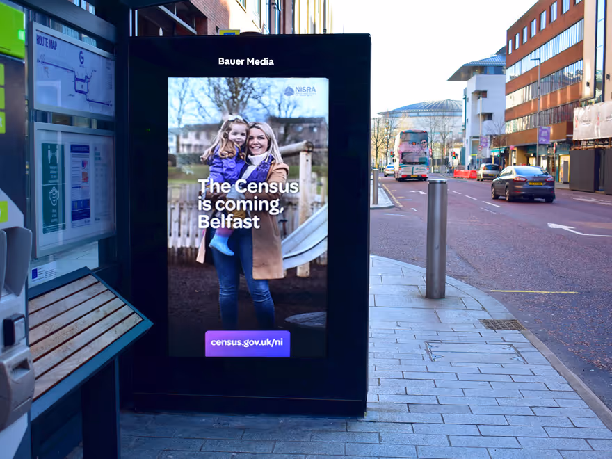 A bus shelter with a digital poster.