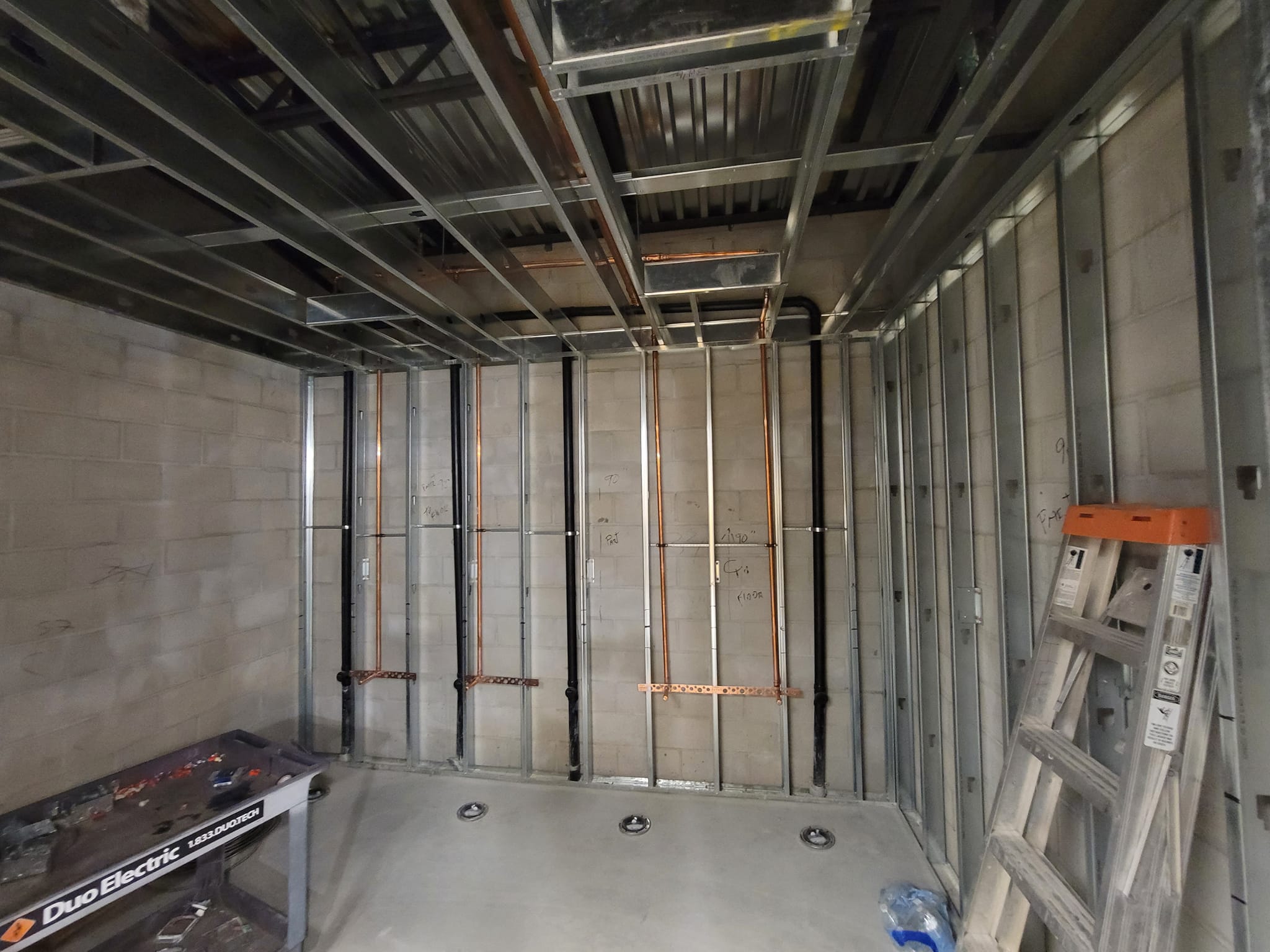 Commercial tenant plumbing upgrade in Murrieta CA with exposed copper and drain lines installed inside framed retail space.