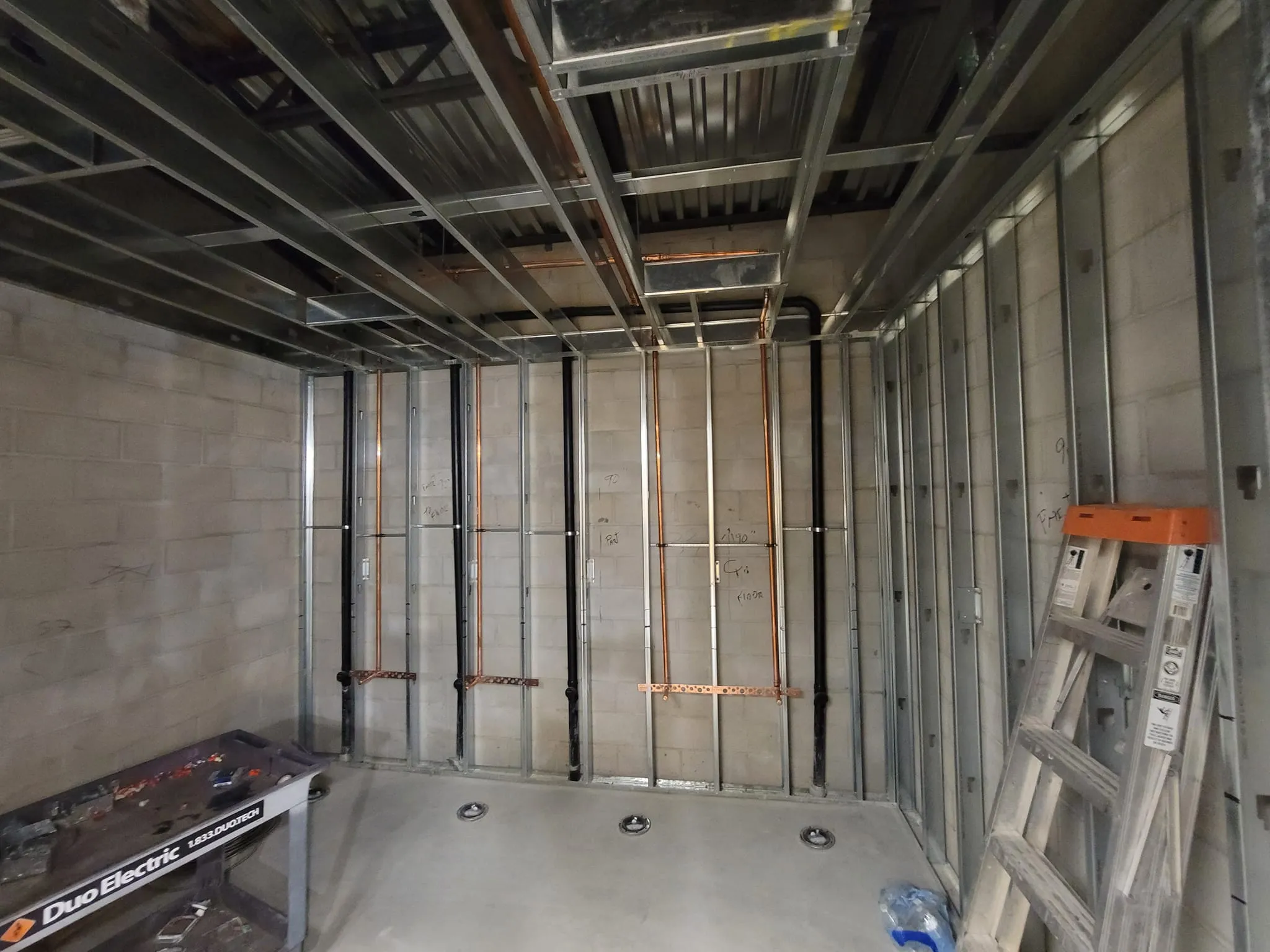 Commercial tenant plumbing upgrade in Murrieta CA with exposed copper and drain lines installed inside framed retail space.