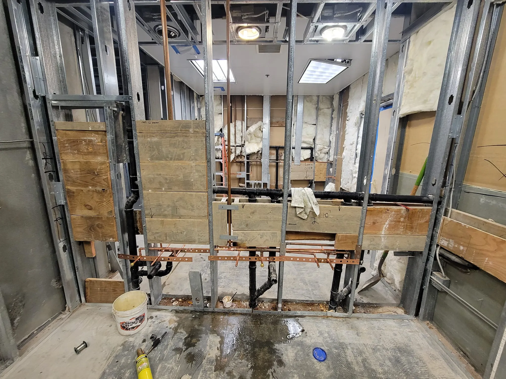 Plumber in Wildomar, CA, showing exposed pipes and construction details for plumbing installation.