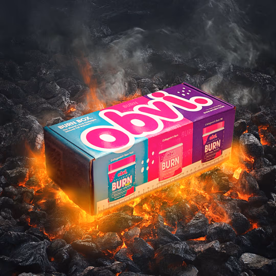 Colorful Obvi Burn supplement box glowing on hot burning charcoal coals with smoke rising.