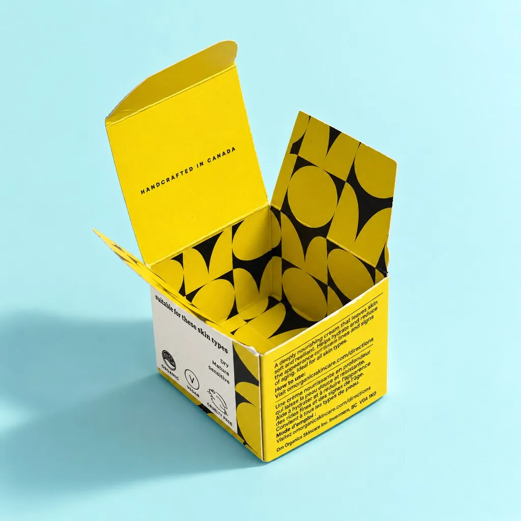Open folding carton for a cosmetic product in blue background.