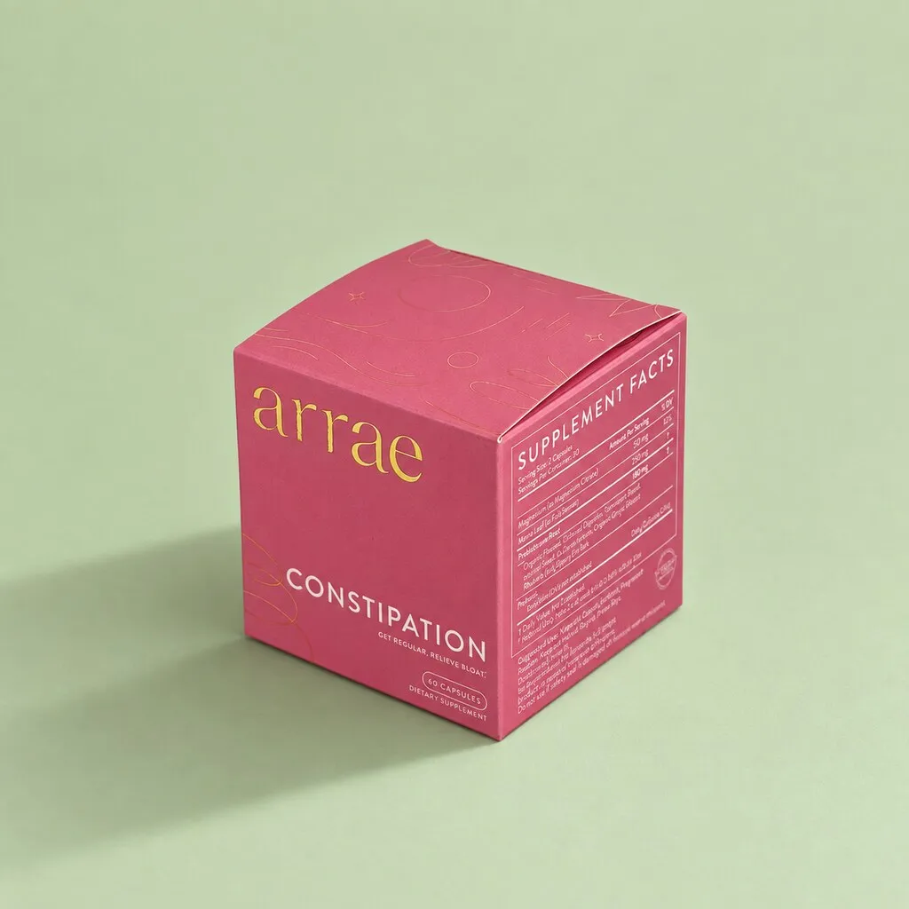 Closed pink folding carton for a cosmetic product in green background.