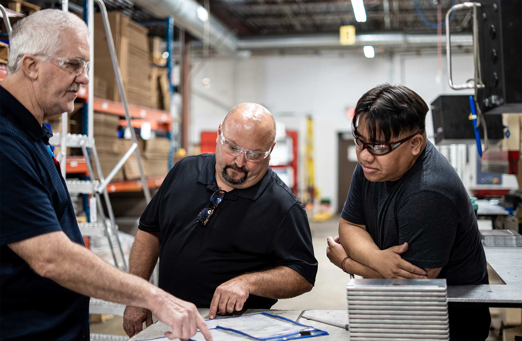 Three employees having a discussion in the warehouse