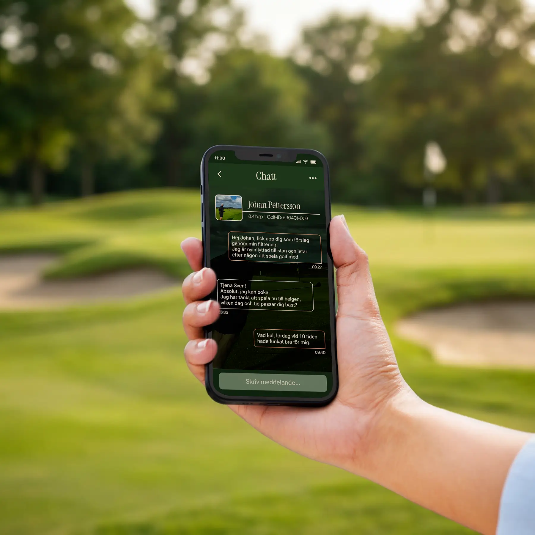 A hand holds a smartphone displaying a chat conversation against the blurred background of a green golf course with sand bunkers and trees.