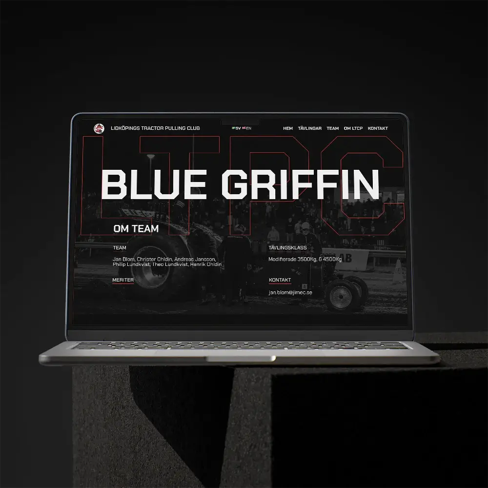 A laptop displaying a dark-themed website for a tractor pulling club, featuring the bold text BLUE GRIFFIN across the screen. The laptop is positioned on a dark, angular surface against a black background.