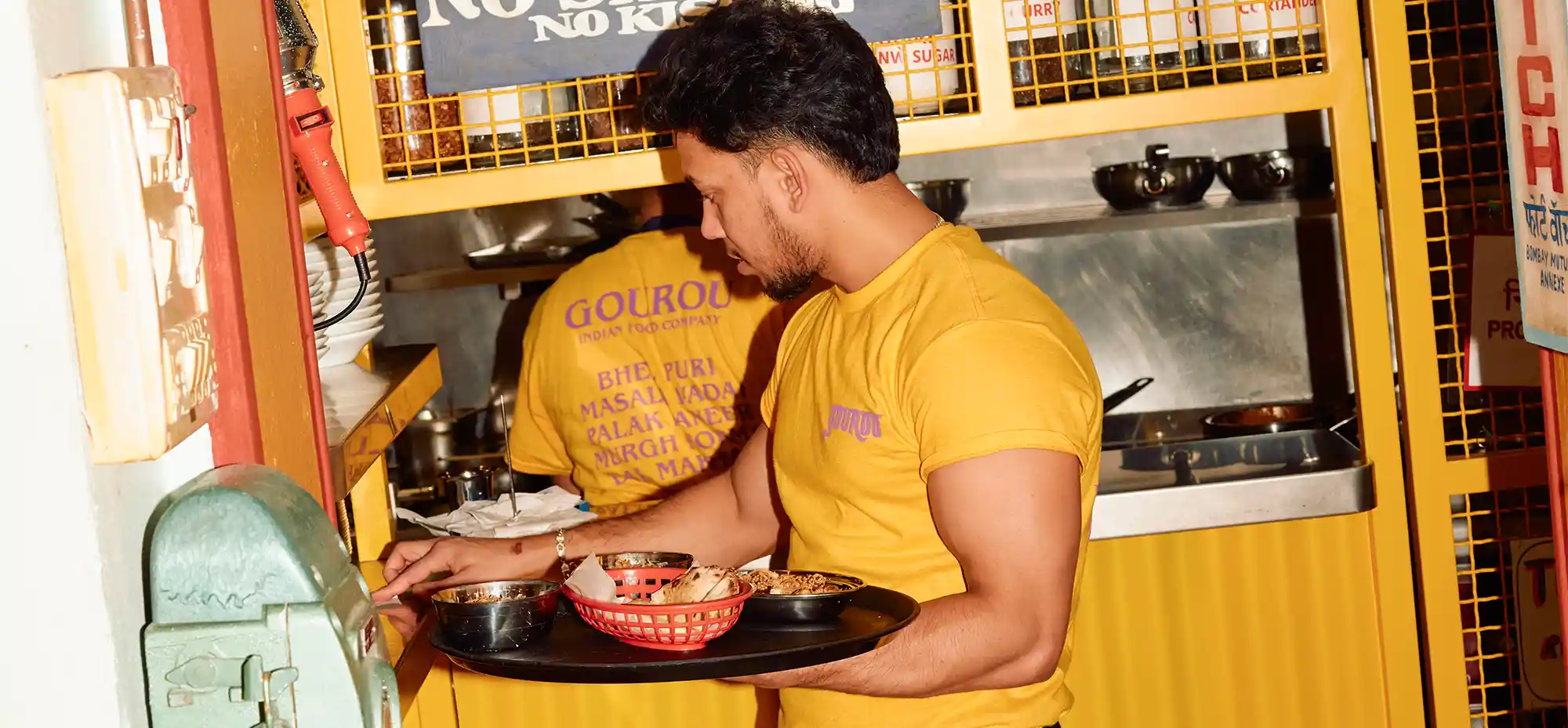 Serveur Gourou en salle récupérant des plats en sortie de cuisine à Paris