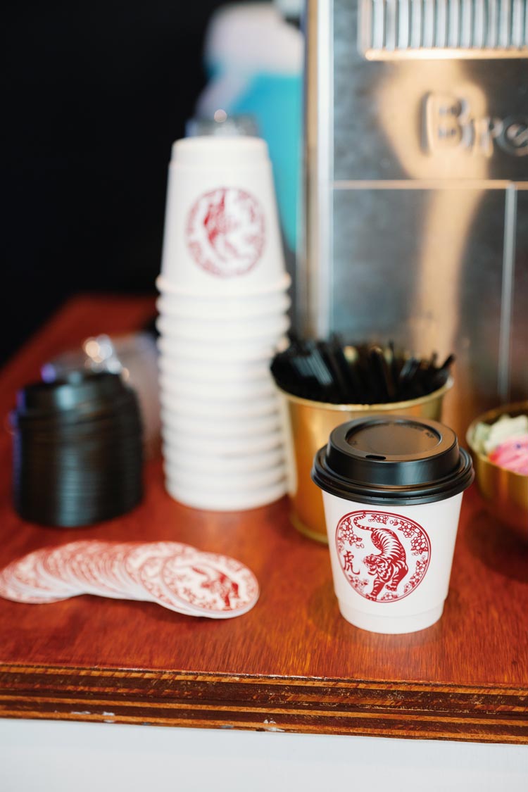 Sunkissed Brew branded coffee cups and lids displayed on a mobile coffee cart setup