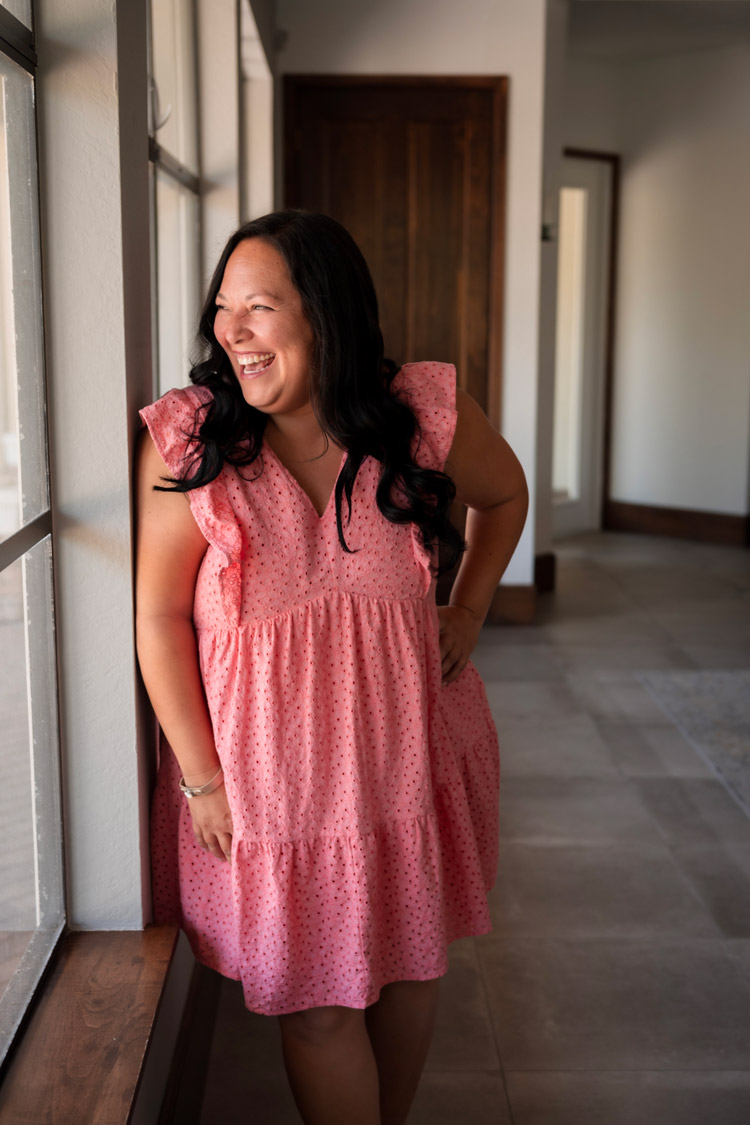 Sunkissed Brew owner smiling and looking out the window in a pink dress during a brand photoshoot